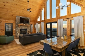 Spacious living room with large windows, fireplace, Smart TV, and mountain views