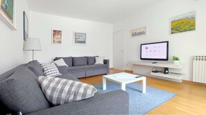 Living room with two sofa beds, entrance to the terrace and big windows.