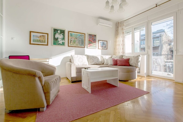 Living room with double sofa bed, armchair and exit to the sunny terrace.