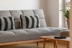 A close-up of the sofa’s textured fabric and decorative black-and-white patterned cushions, adding contrast and style.


