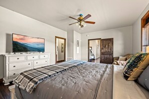 The bedroom includes a dresser and a large Smart TV.