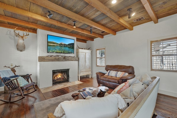 Gather around the cozy fireplace in this spacious living room.