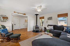 Living room with sectional, wood-burning fireplace and SmartTV.