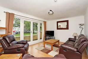 Lounge leading to a balcony looking over development gardens