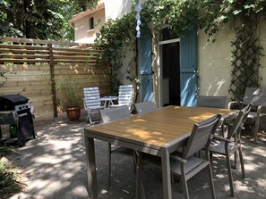 La terrasse , avec salon de jardin et barbecue.