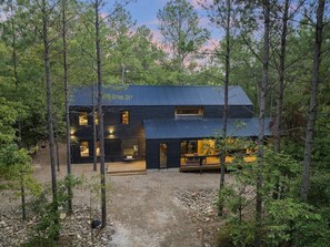 Modern black cabin set down from the road