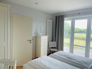 Schlafzimmer mit Doppelbett und Terrassenausgang
