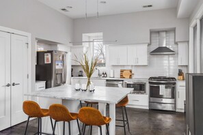 Fully-equipped chef's kitchen with seating for 6 at the island, right next to the back door to our fenced-in yard. Perfect space for cooking & enjoying your next meal.