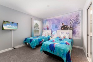 Delight your kids with this enchanting themed bedroom, featuring vibrant bedding and a captivating mural for a magical stay.