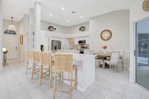 The kitchen contains a bar height counter for conversational seating