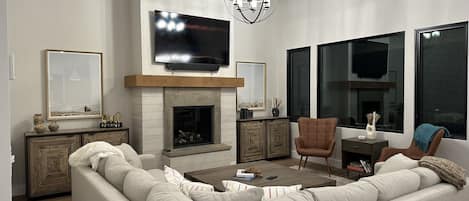 Spacious living room: comfy couch, smart TV, big coffee table to play games