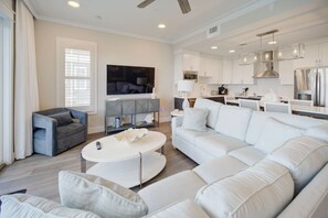 A spacious and modern living room that flows into the dining area, perfect for entertaining or relaxing.