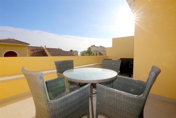 Terrace facing south with outdoor dining area and relaxing seating for four guests