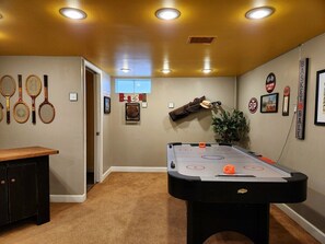 Family room w/ 65" HDTV and Air Hockey Table