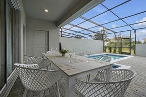 Sip and dine al fresco in your screened lanai overlooking the sparkling pool. This serene outdoor dining space is the perfect spot to relax after a day at nearby Disney. Enjoy privacy, comfort, and Florida's balmy evenings