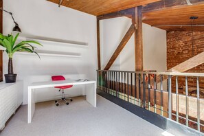 A lofted study nook caters to those working from home with a desk and chair.
