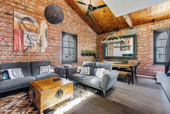 The dining and living area is tastefully decorated to compliment the apartment's pitched timber ceilings and exposed brick walls.