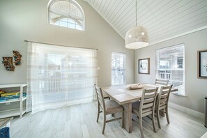 Bright dining area with a high ceiling, natural light, and seating 6