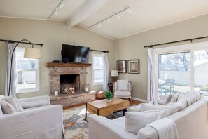 Enjoy quality time with family and friends in the living room, featuring a comfortable sofa, armchairs, and a flat-screen TV for entertainment