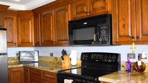 Kitchen with appliances, granite counter and cabinets