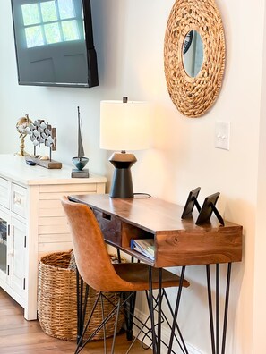 Large wifi tv, console and desk located in the living room. 