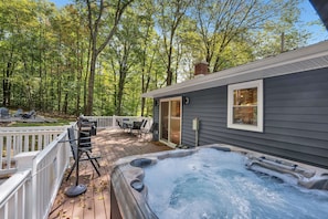 Outdoor Oasis: Relax in the hot tub surrounded by vibrant forest views and a spacious deck!