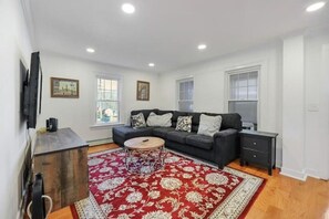 Cozy living room with an oversized sofa, Wi-Fi TV, and electric fireplace.