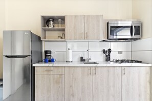 Modern Kitchen of the Apartment in Noord Aruba - Well-lit space with strategically placed task lighting - Elegant and coordinated color palette for a cohesive look - Fully Equipped