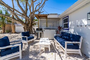 Outdoor Sitting area in backyard with Grill and beach and pickleball equipment