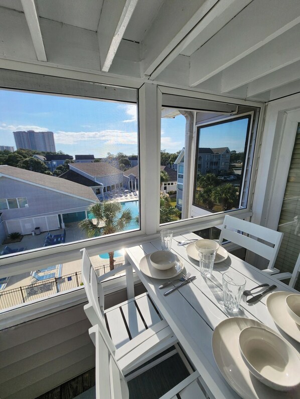 Screened-in outdoor balcony overlooking the pool