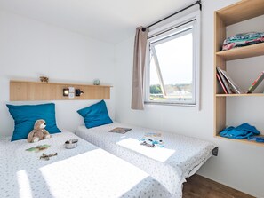 Bright and cheerful twin bedroom with fun decorative touches, offering a delightful space for guests.
