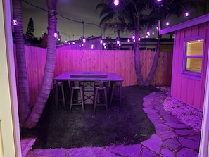 Gorgeous backyard with lavender mood lighting, and a huge outdoor fire table.