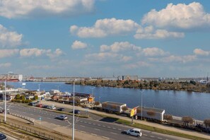 A breathtaking view of the harbor and waterfront from the apartment, with blue skies and a scenic cityscape.

