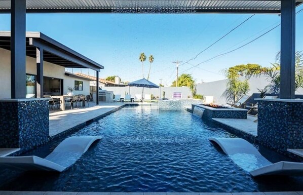 Covered Patio area with rain waterfall into pool