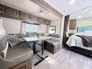 RV interior: booth seating, bed. Compact living.