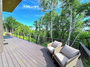 Large spacious deck with seating and mountain views.
