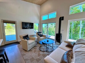 Living area with TV, fireplace and adjacent kitchen and dining area