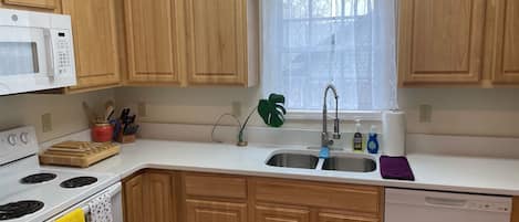 The updated kitchen features new white quartz counters, full sized appliances and a dishwasher to make cooking and clean up easy.