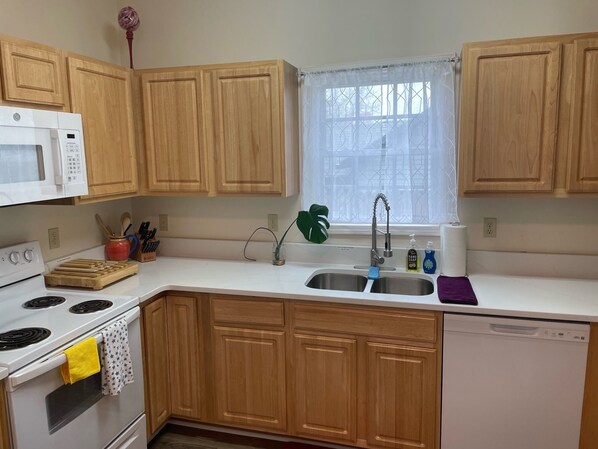 The updated kitchen features new white quartz counters, full sized appliances and a dishwasher to make cooking and clean up easy.