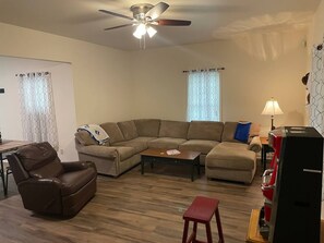 The main living area at the Durham Bull Pen has a large 55" Smart TV for streaming your services, a bunch of comfy seating to relax and a dining area.
