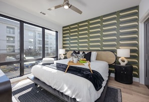 Unit 1: Primary bedroom with King bed, smart TV, large walk-in closet, and ensuite bathroom with walk-in shower.