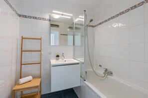 Efficient bathroom with bathtub and shower hose