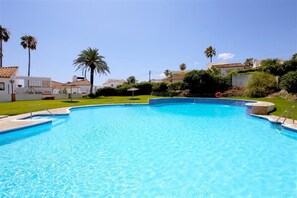 Inviting communal swimming pool surrounded by gardens