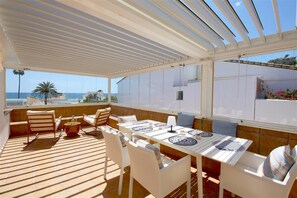 Large terrace with sea views, relaxing seating and outdoor dining area for six guests