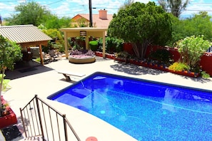 Stunning all tile pool with tables, beds and tv/bar