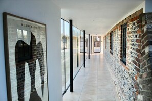 A glass walkway connect the rooms and allows stunning views across the open farmland behind.