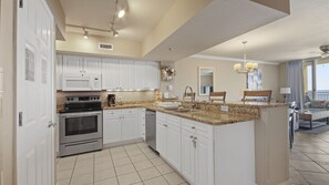 The fully equipped kitchen features granite countertops and stainless-steel appliances.