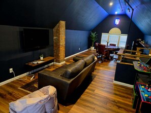 Attic game room with arcade games and poker table