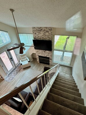 Looking down the stairs from Bedroom #1 at fireplace living area