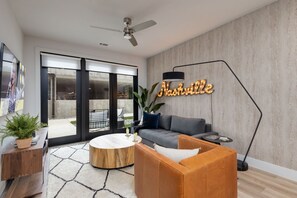 1st Unit: Bright living room with comfortable seating, smart TV, designer decor, and access to the private patio.